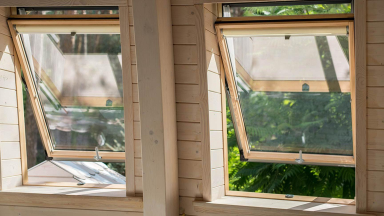 Geöffnete Designo R7 Hoch-Schwingfenster in einem Holzhaus