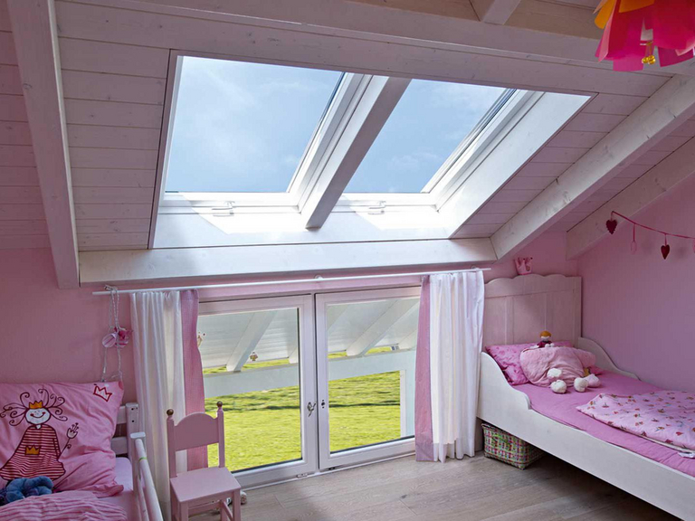 Rosafarbenes Kinderzimmer mit zwei Betten und großer Fensterfläche im Zwillingseinbau