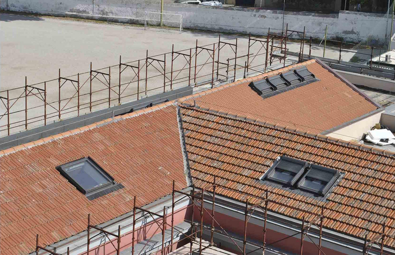 Sassari, Casa dello Studente: finestre per tetti Roto con apertura a bilico, elettriche, in legno, con doppio vetrocamera ad isolamento termoacustico, antiappannamento e antigrandine, dal valore termoisolante di Uw 1,2 W²K e con distanziale in PVC per evitare possibili condense perimetrali all’interno del vetrocamera stesso. 